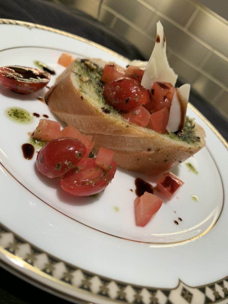 Amazen tomato bruschetta plated on white and gold china